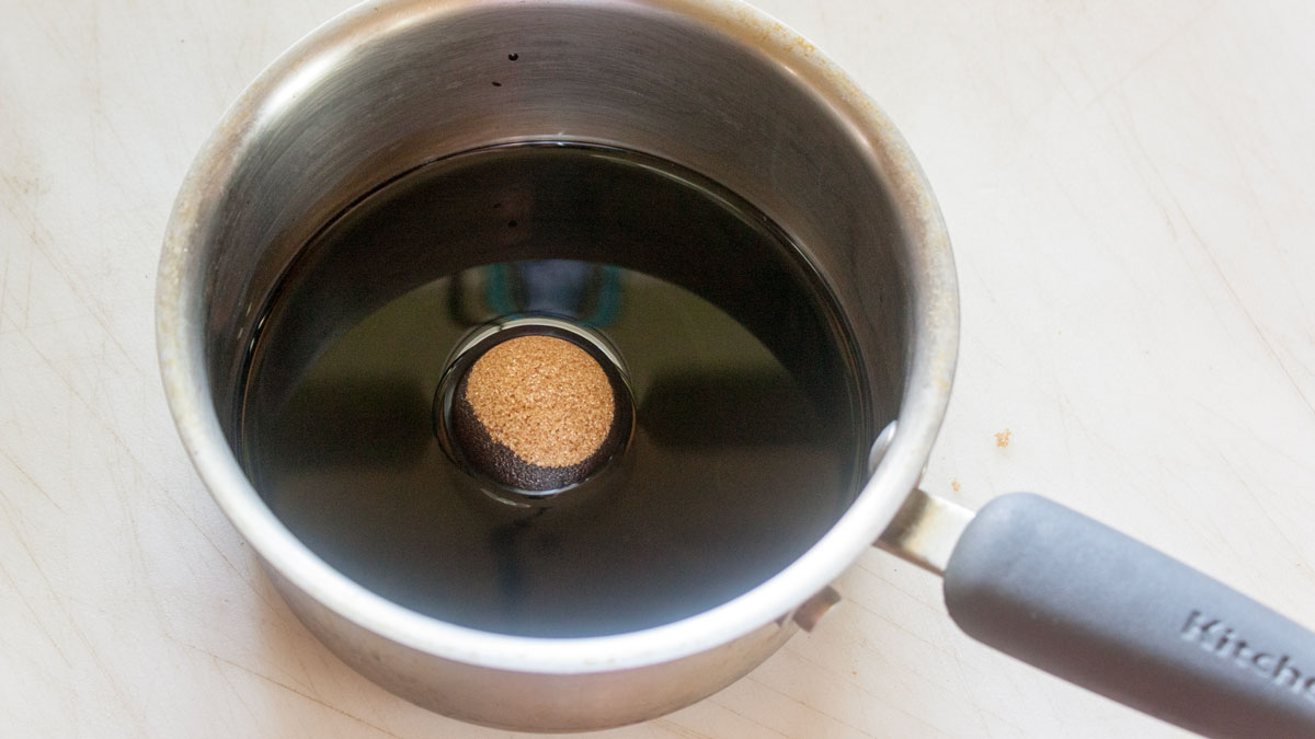 Brown sugar added to balsamic vinegar in a small saucepan.