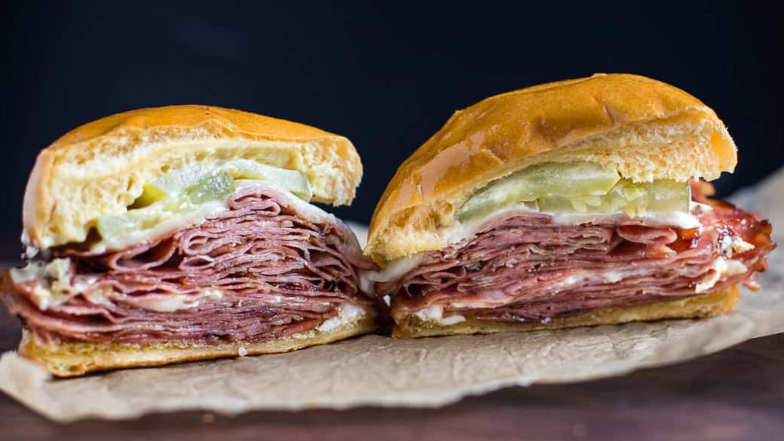 Two mortadella sandwich on a black background.