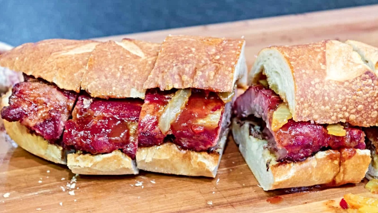 Sliced mcrib sandwich on a wooden board.