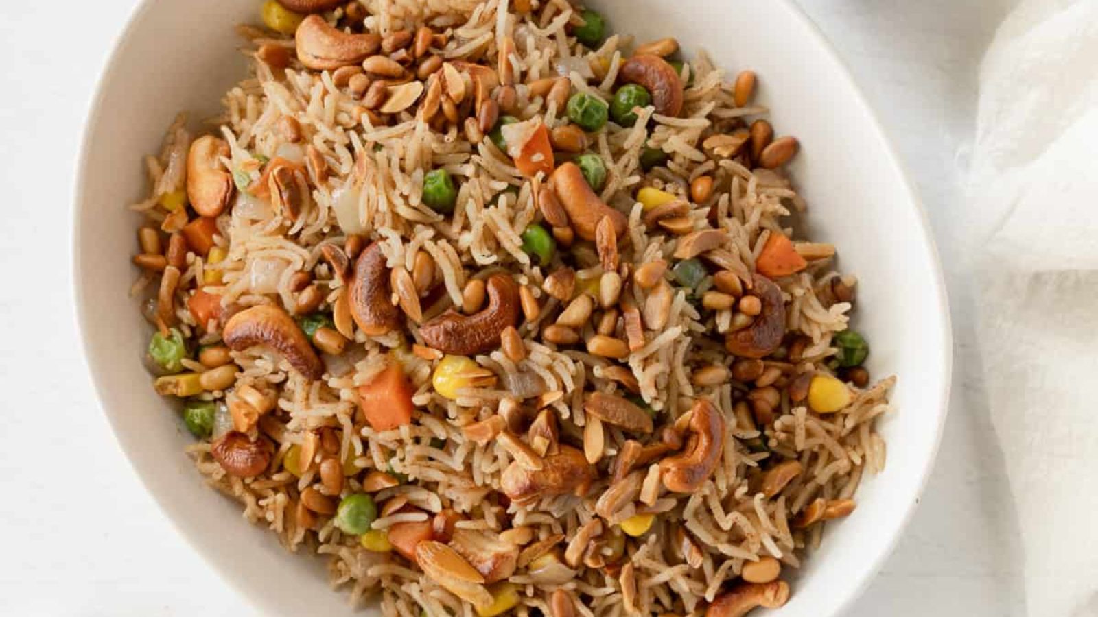 Rice with toasted nuts and veggies in a bowl.
