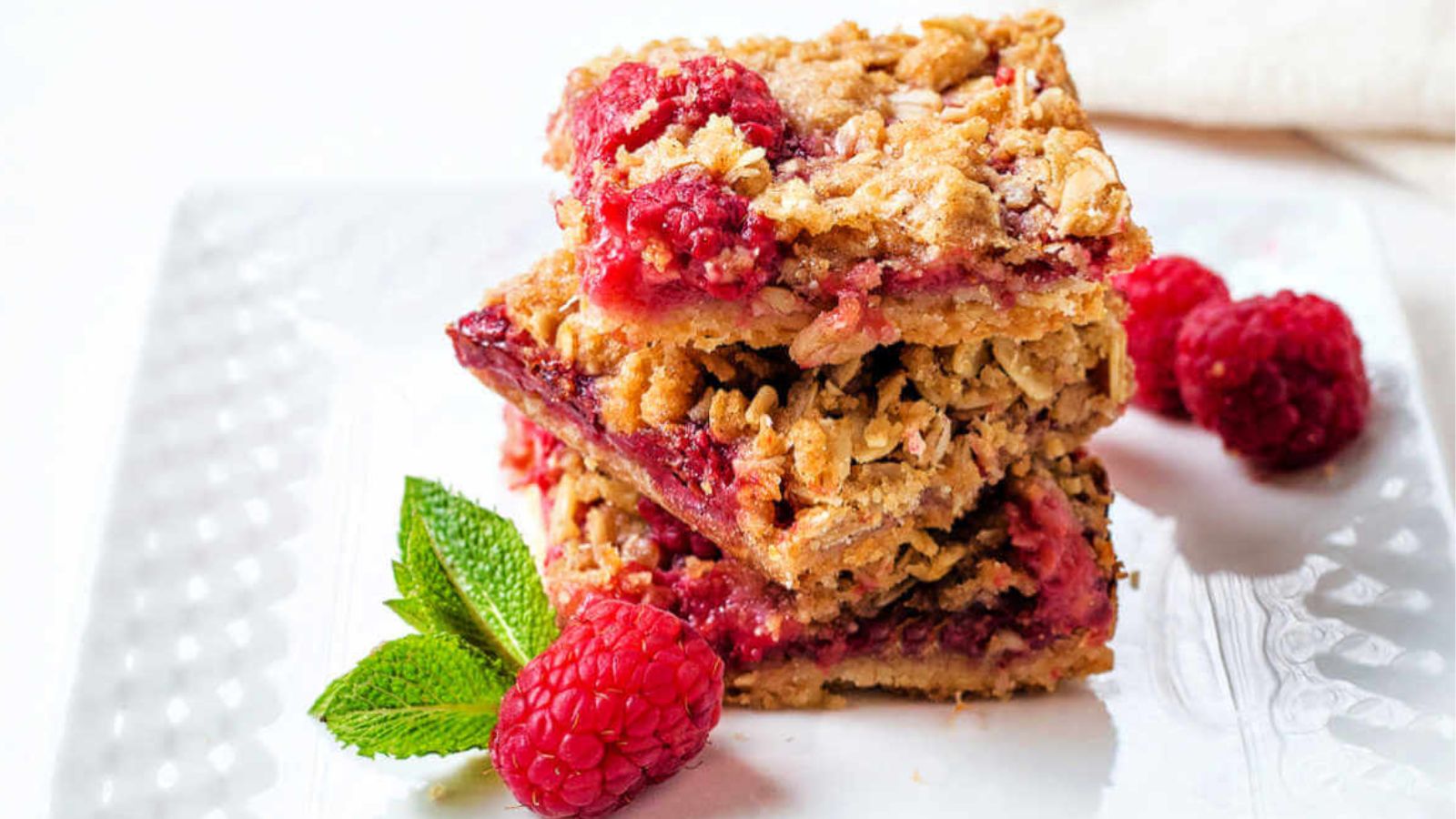Stack of oatmeal bars with raspberries.