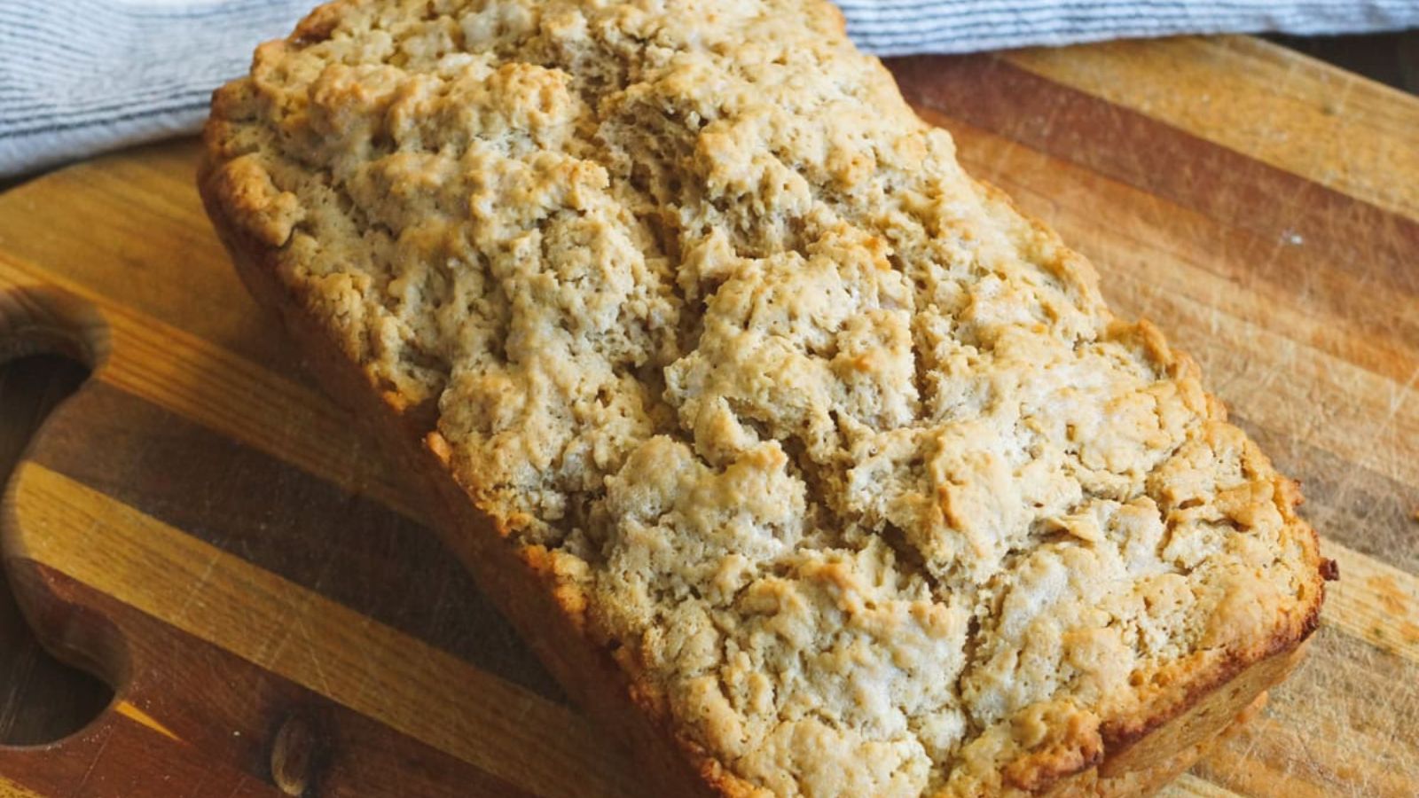 A whole beer bread on a wooden board.