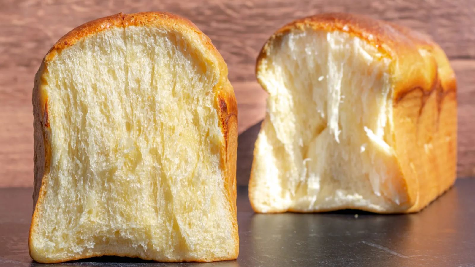 Sliced brioche bread on a black surface.