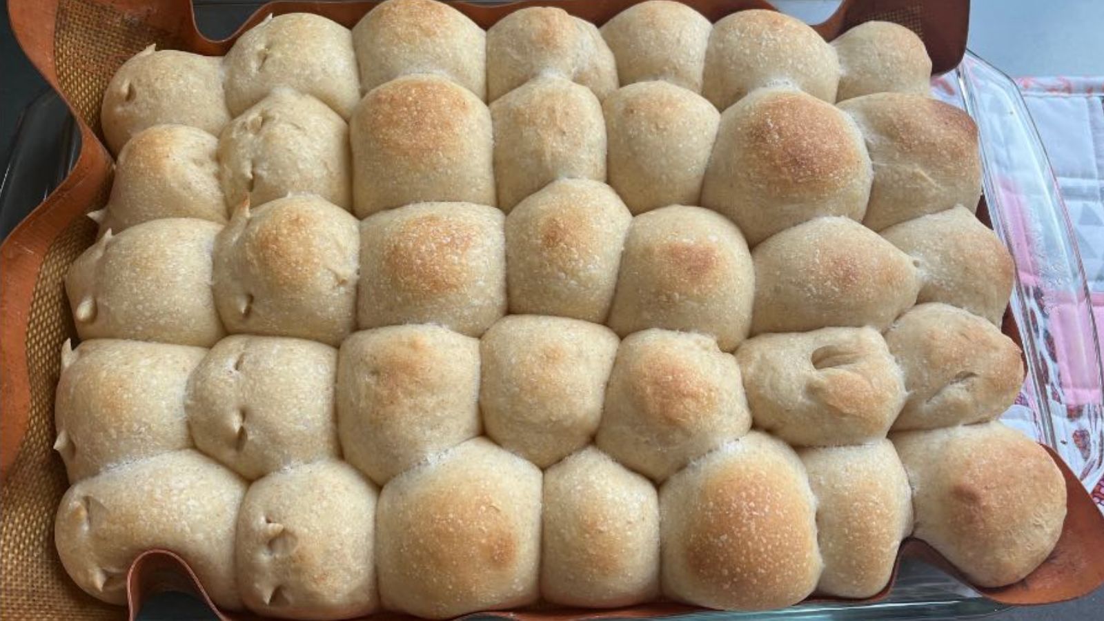 Sourdough hawaiian rolls on a tray.