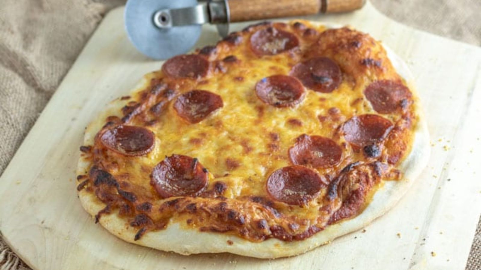 Sourdough pizza on pizza peel.
