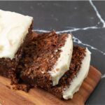 Sliced carrot cake bread on a long cutting board.