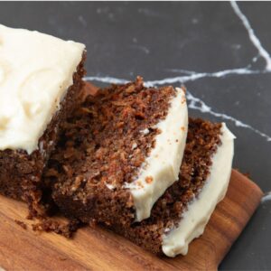 Sliced carrot cake bread on a long cutting board.