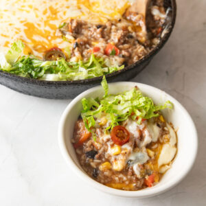 Creamy, cheesy bowl of skillet dinner on a white bowl.