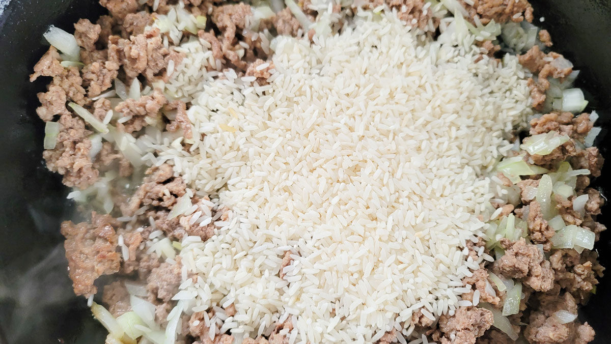 Rice added to the meat mixture.