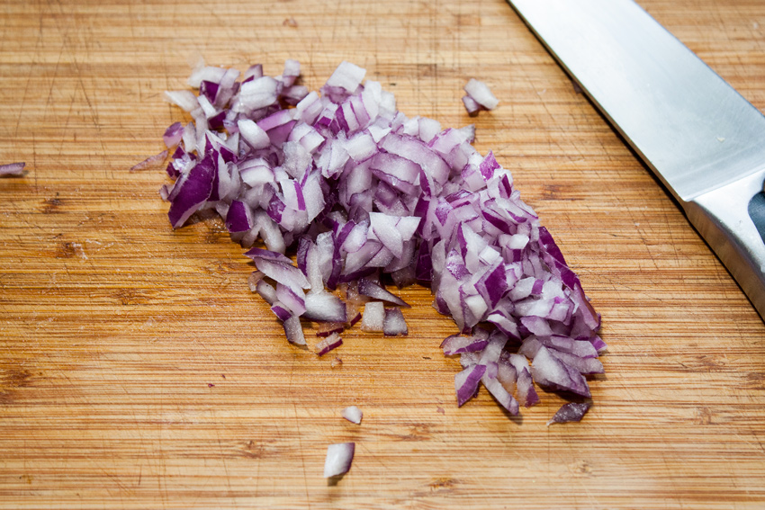 Diced red onion on a board.