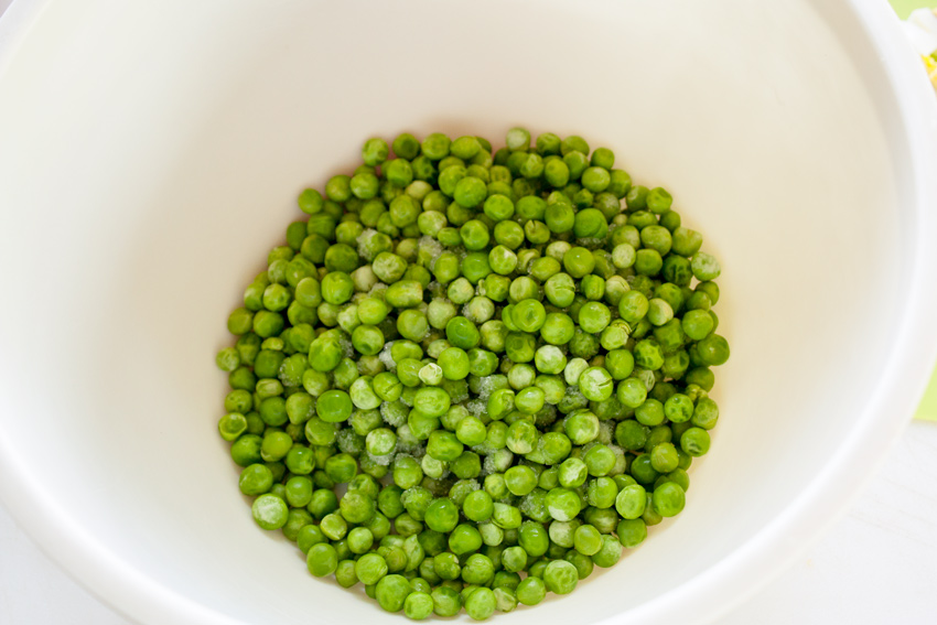 Mixing bowl with peas added.