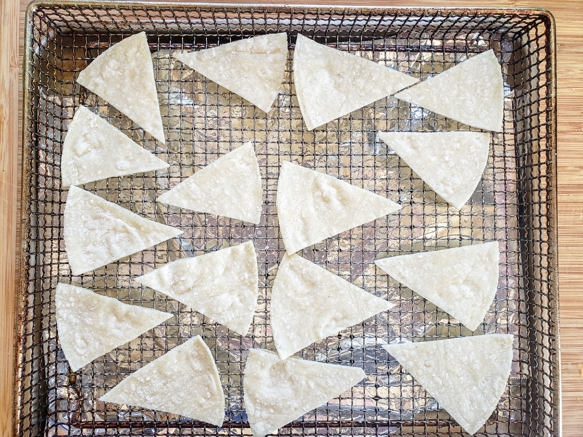 Tortilla triangles on an air fryer basket.