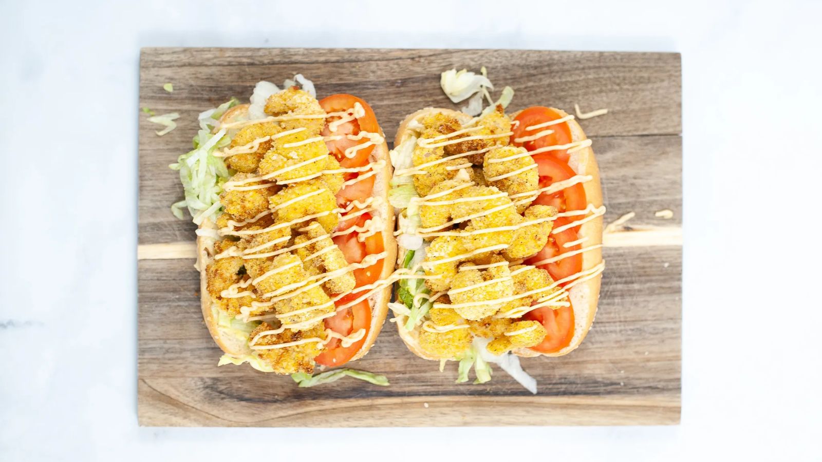 Shrimp po boy sandwich on a wooden board.