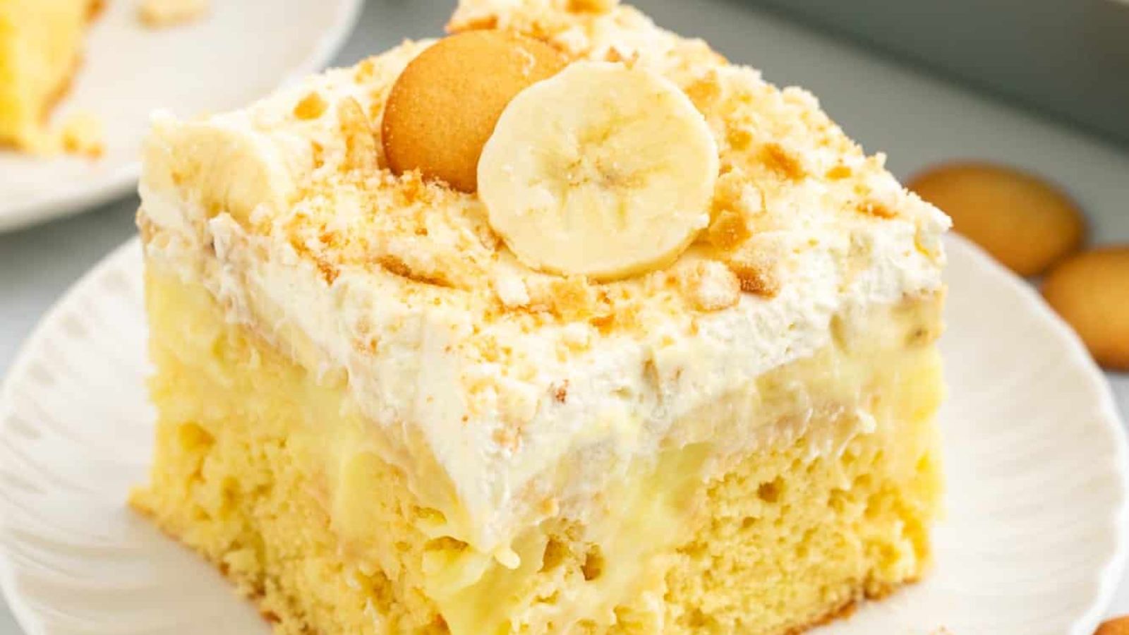 A slice of banana poke cake on a plate.