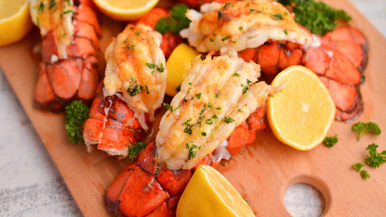 Lobster tails on a wooden board.