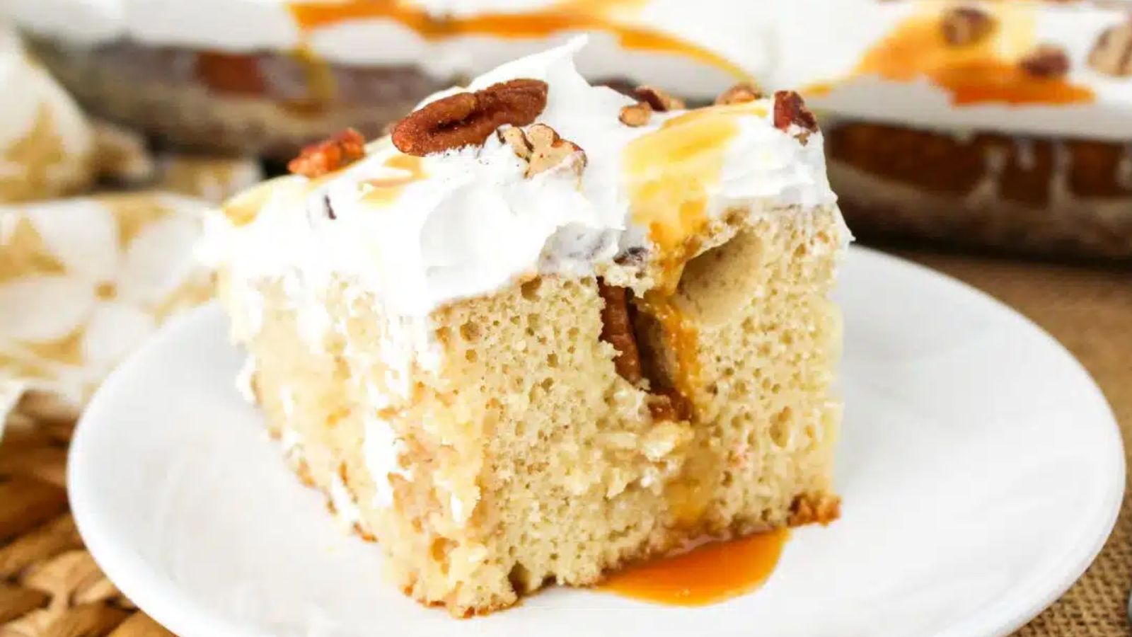 A slice of pecan poke cake on a plate.