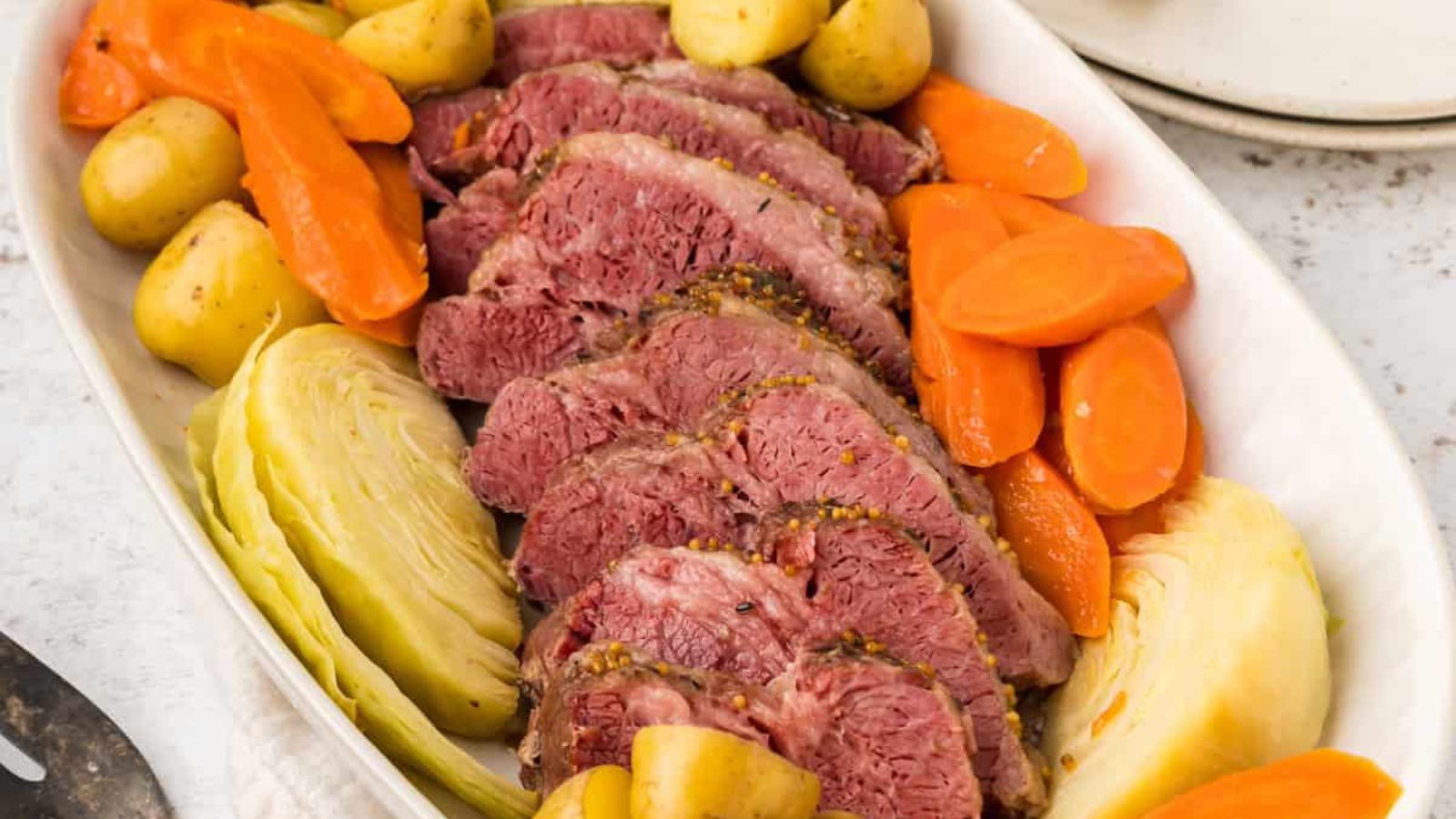 Corned beef, potatoes, carrots and cabbage on a plate.