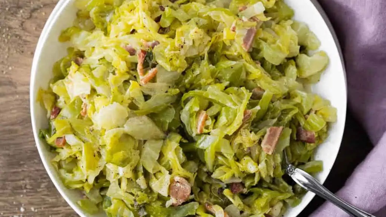 Creamed cabbage with bacon in a bowl.