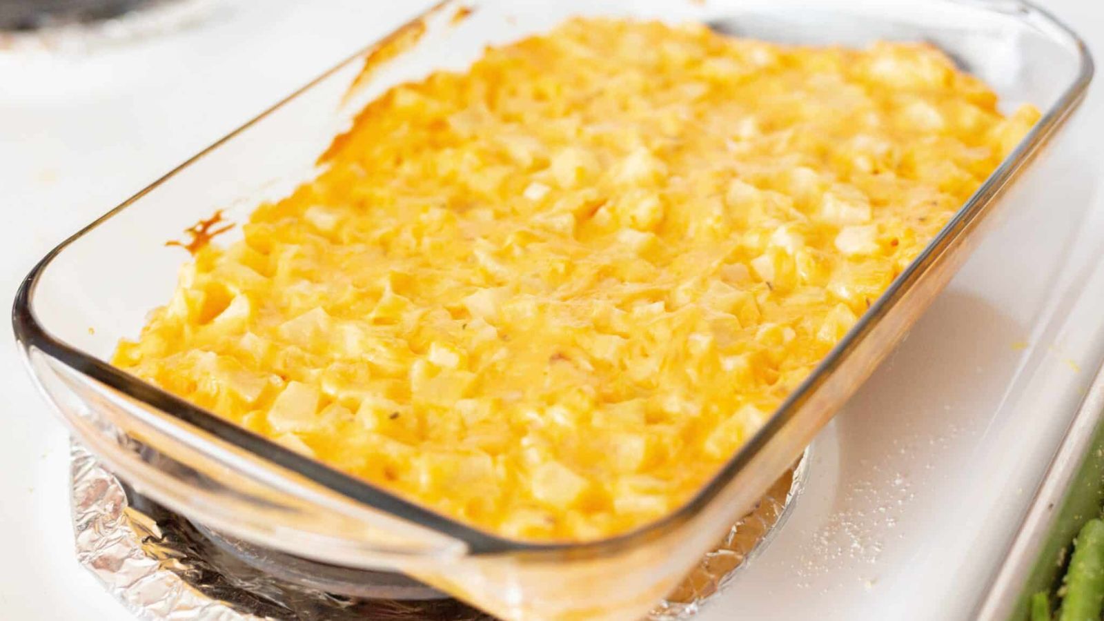 Cheesy potatoes on a glass tray.