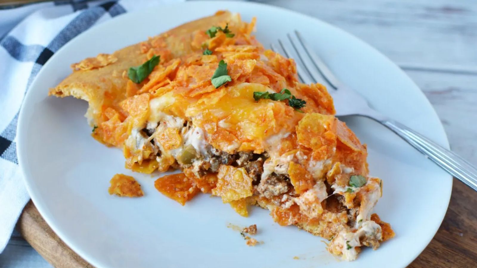 A slice of doritos taco pie on a plate.