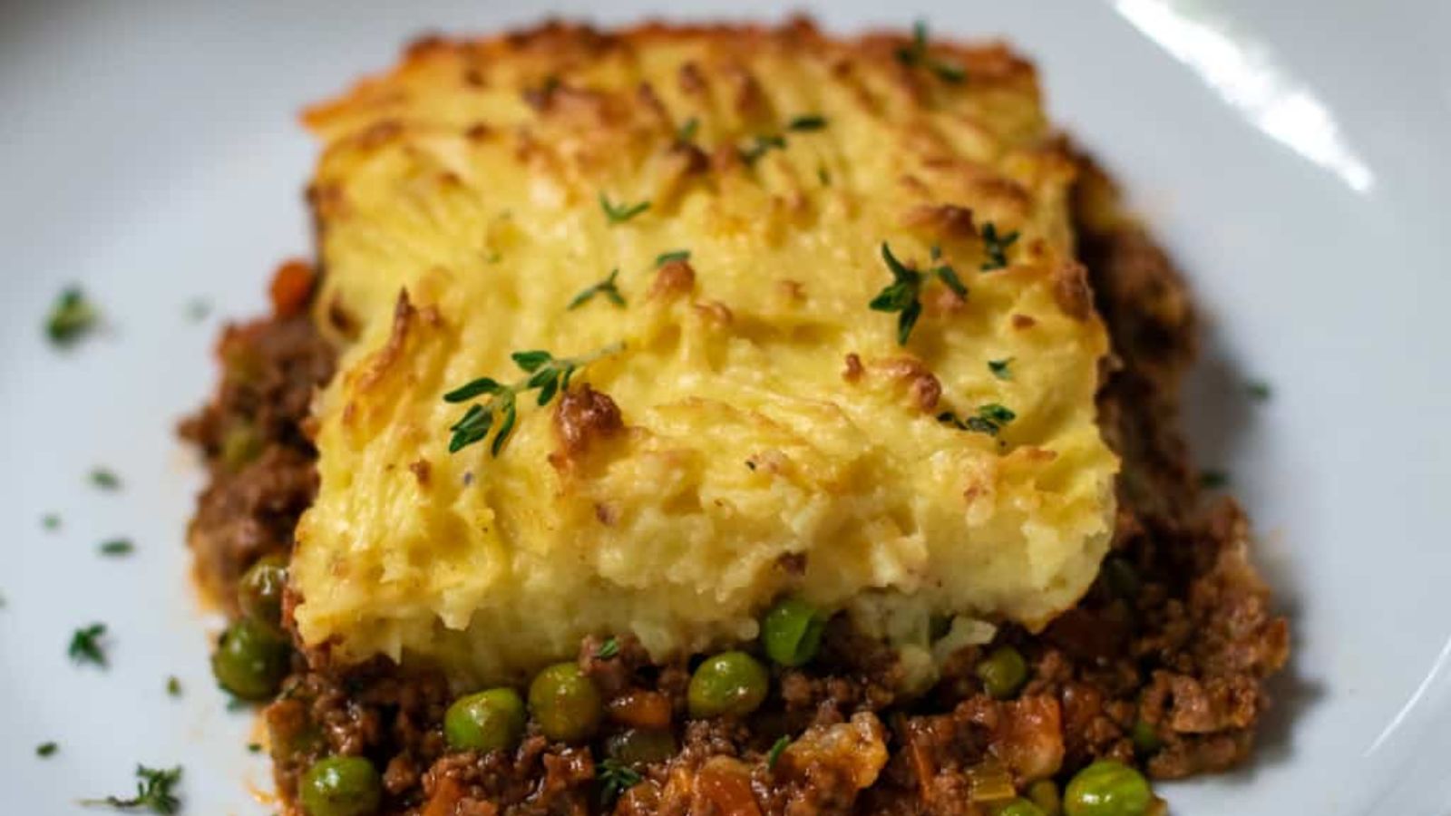 A slice of cottage pie on a plate.