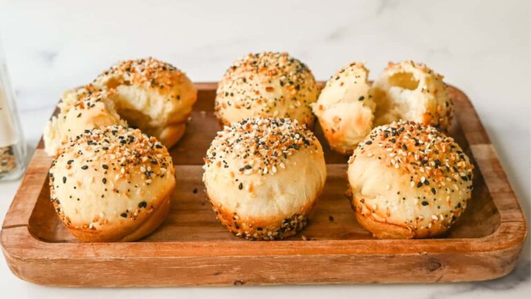 Bagel with cream cheese on a wooden board.