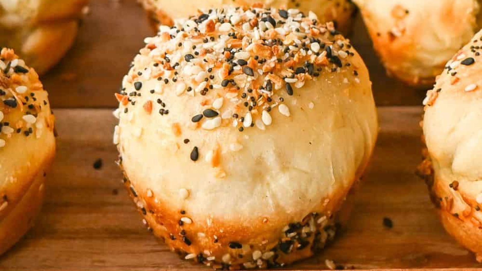 Bagel with cream cheese on a wooden board.