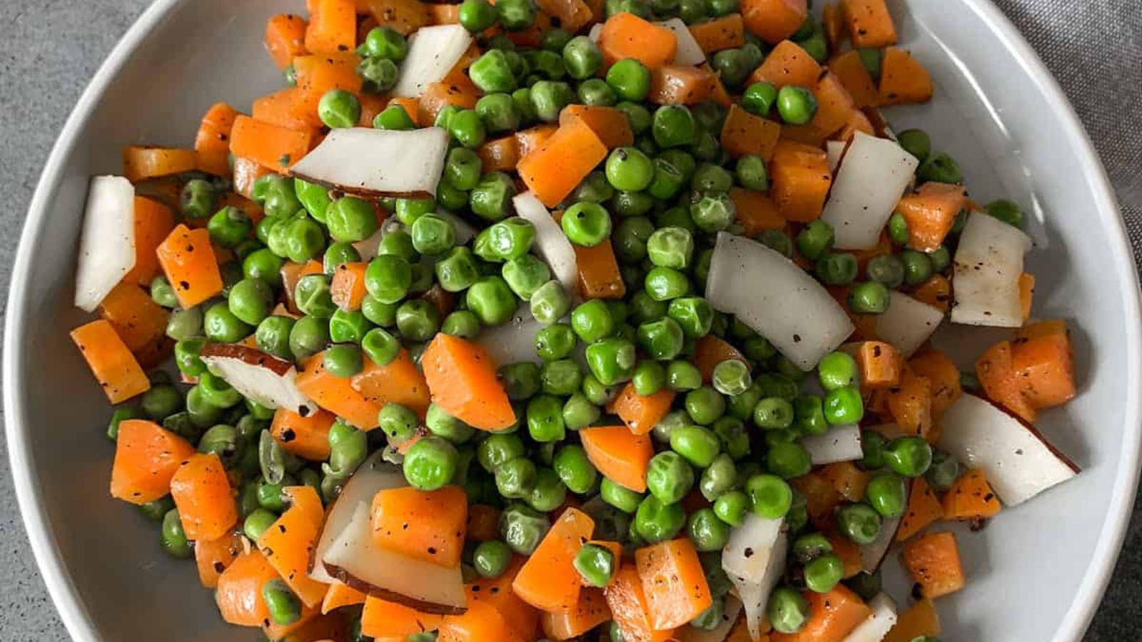 Peas and carrots on a plate.
