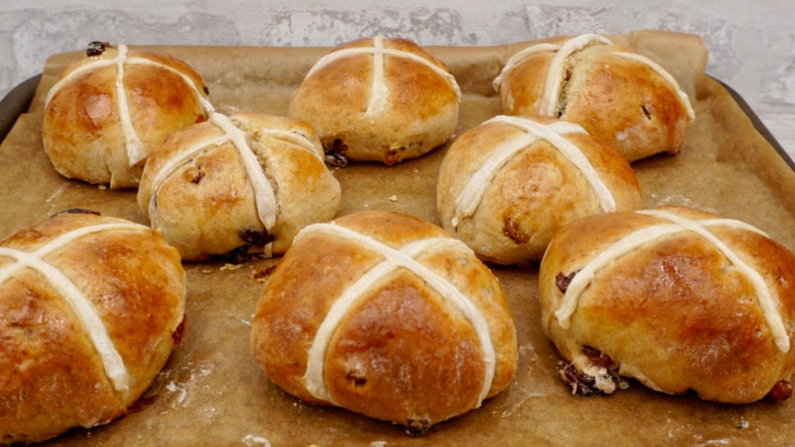 Cross buns on wooden plate.