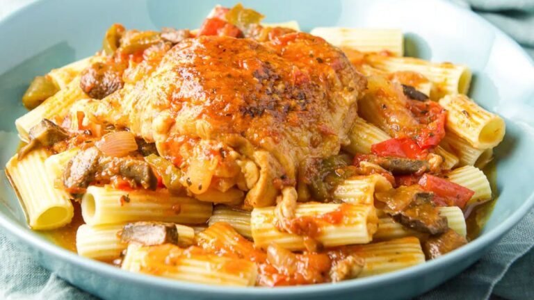 Chicken breast atop pile of pasta.