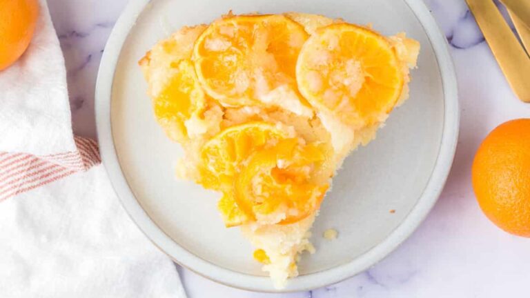 A slice of orange cake on a plate.