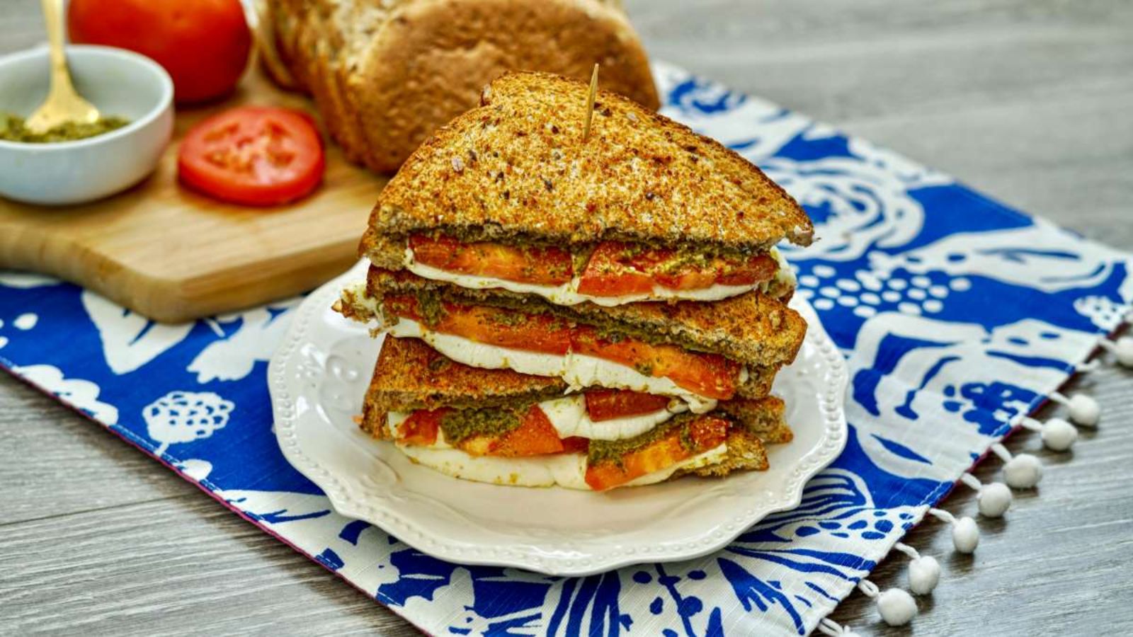 Grilled cheese with tomato on a plate.