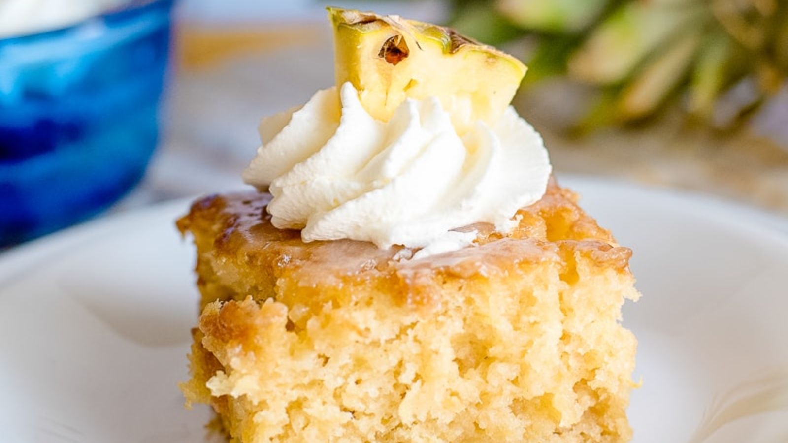 A slice of poke cake with pineapple.