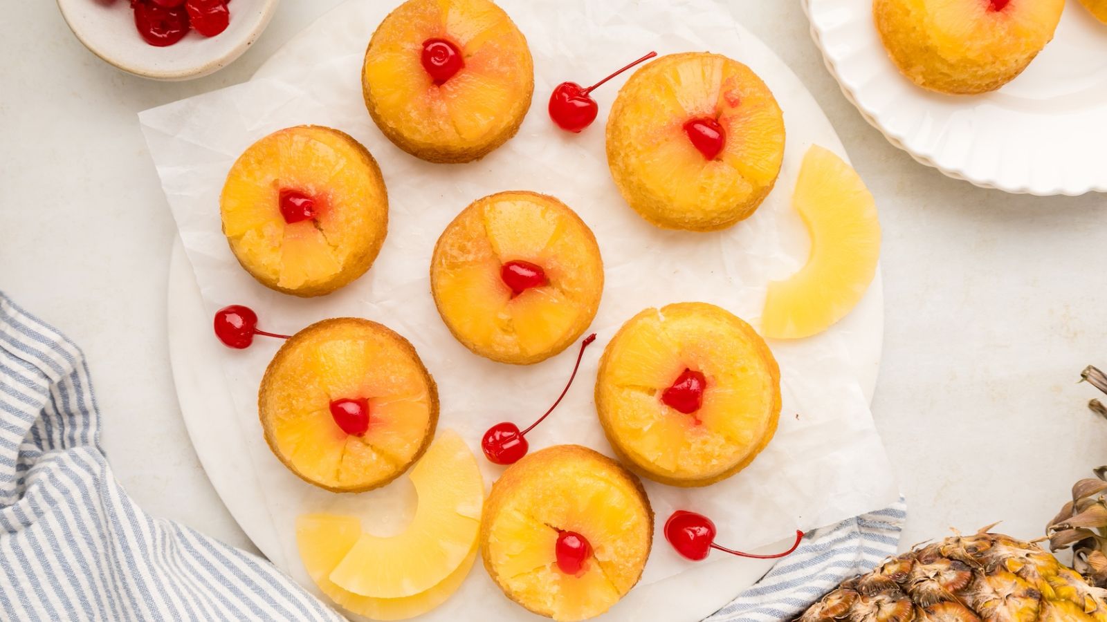 Pineapple upside down cupcakes on a plate.