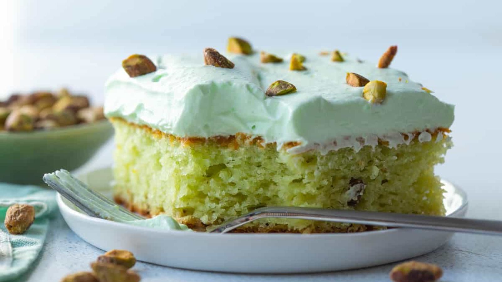 A slice of pistachio cake on a plate.
