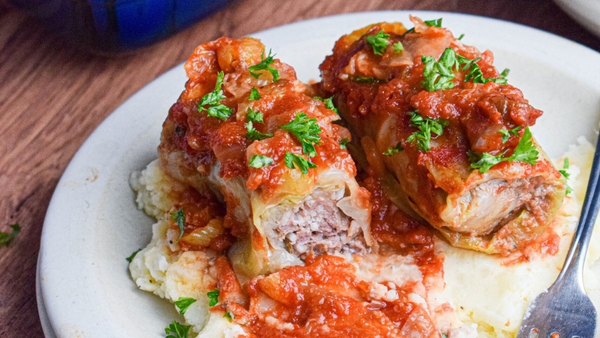 Two cabbage rolls with sauce.