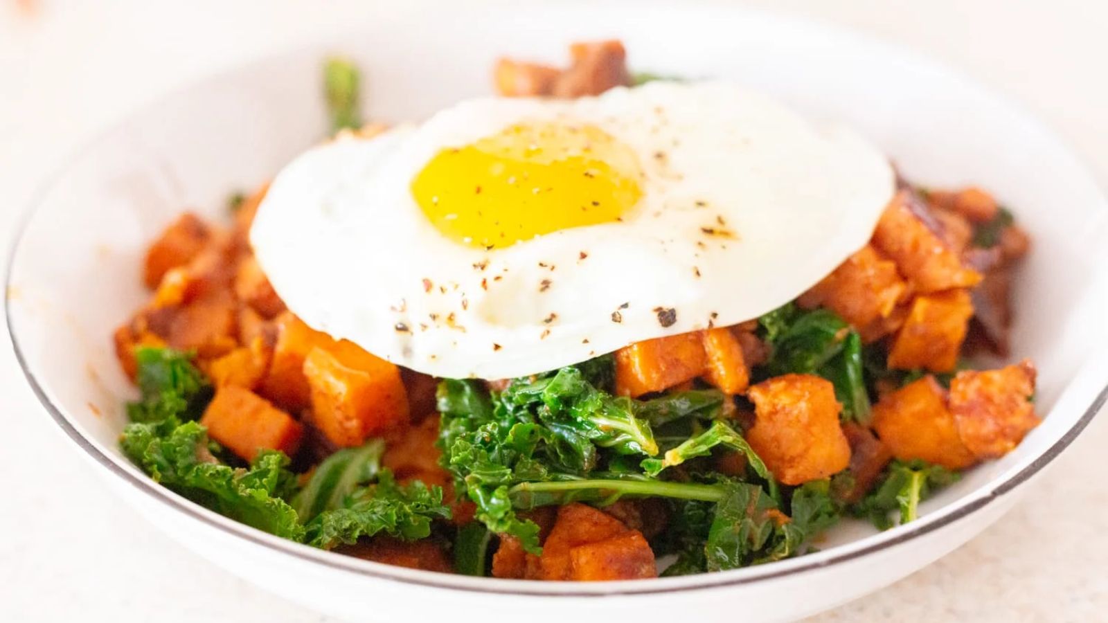 Sweet potato with kale and egg in a bowl.