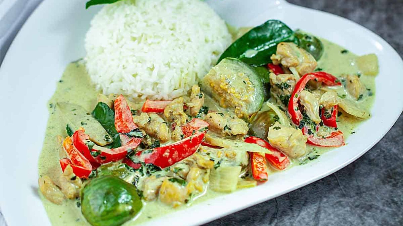 Green curry with rice on a plate.
