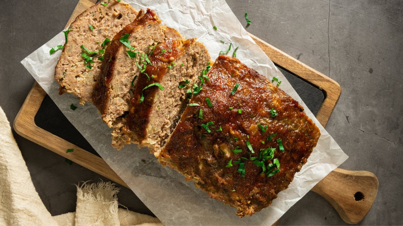 Sliced meatloaf on a wooden board.