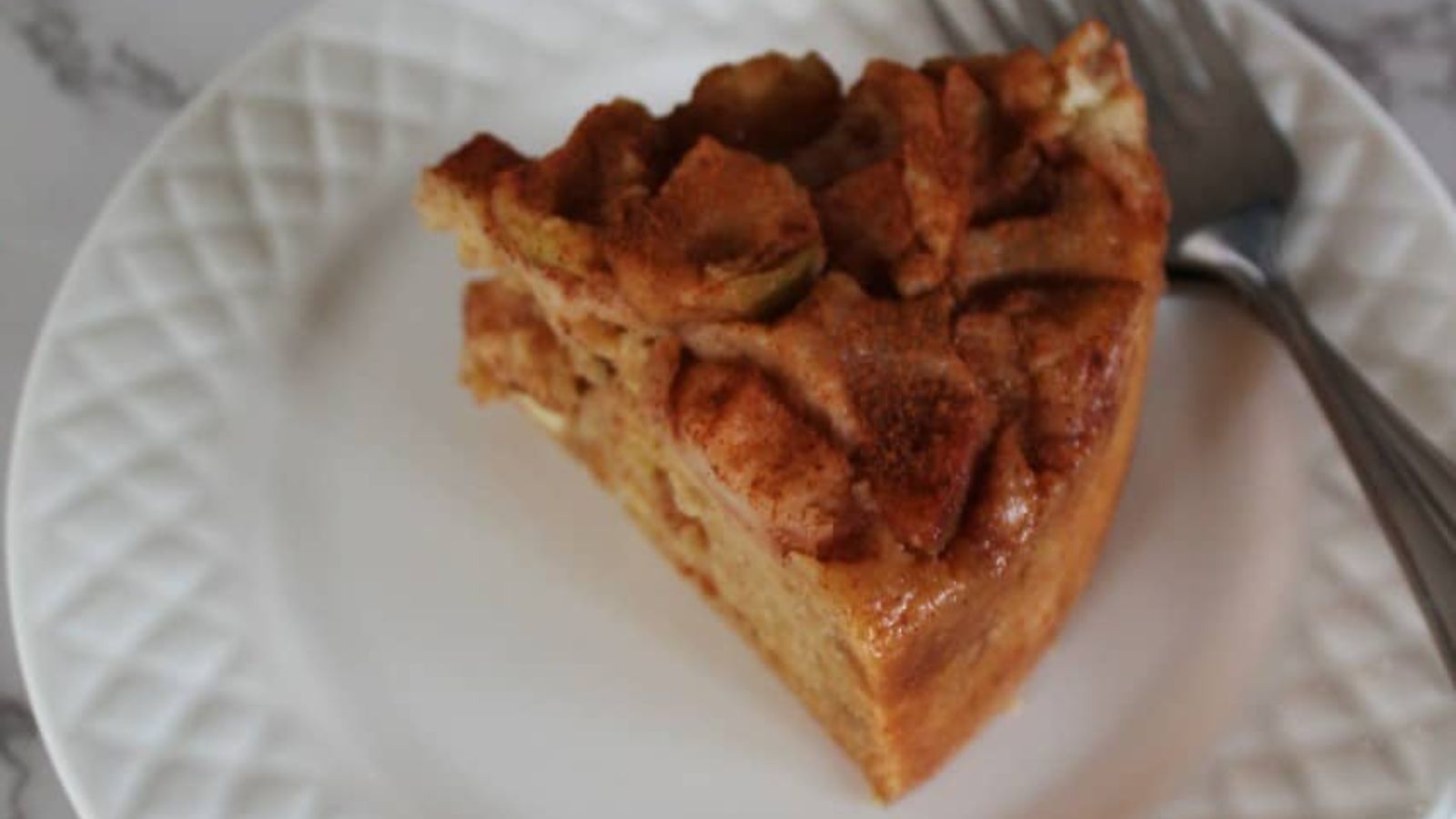 A slice of apple cake on a plate.