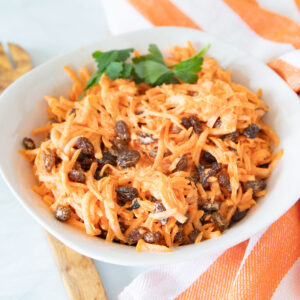 White bowl filled with carrot salad.