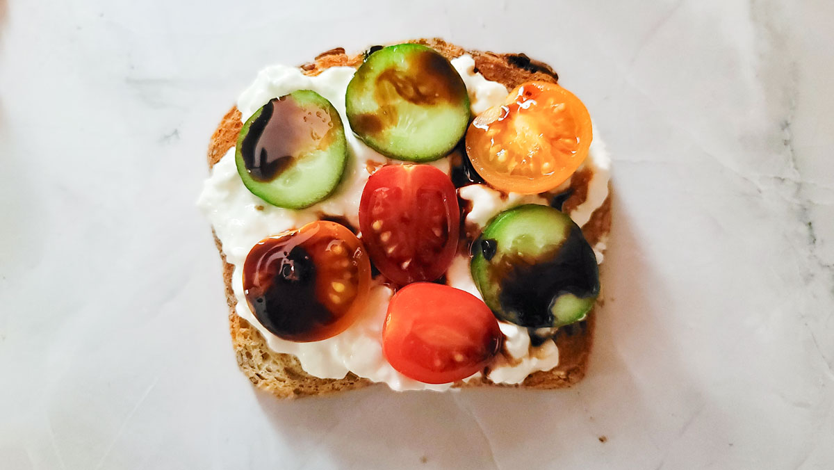 Cottage cheese toast topped with cucumbers, tomatoes and balsamic drizzle.