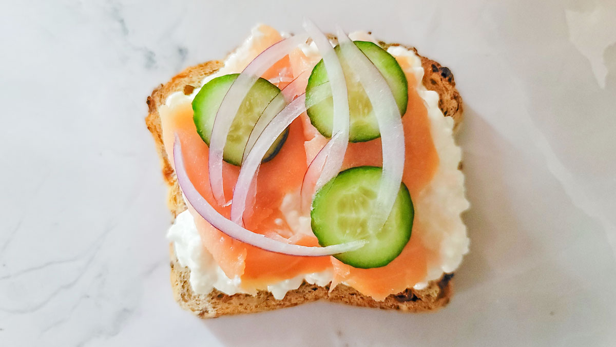 Cottage cheese toast topped with lox, red onion and cucumber slices.