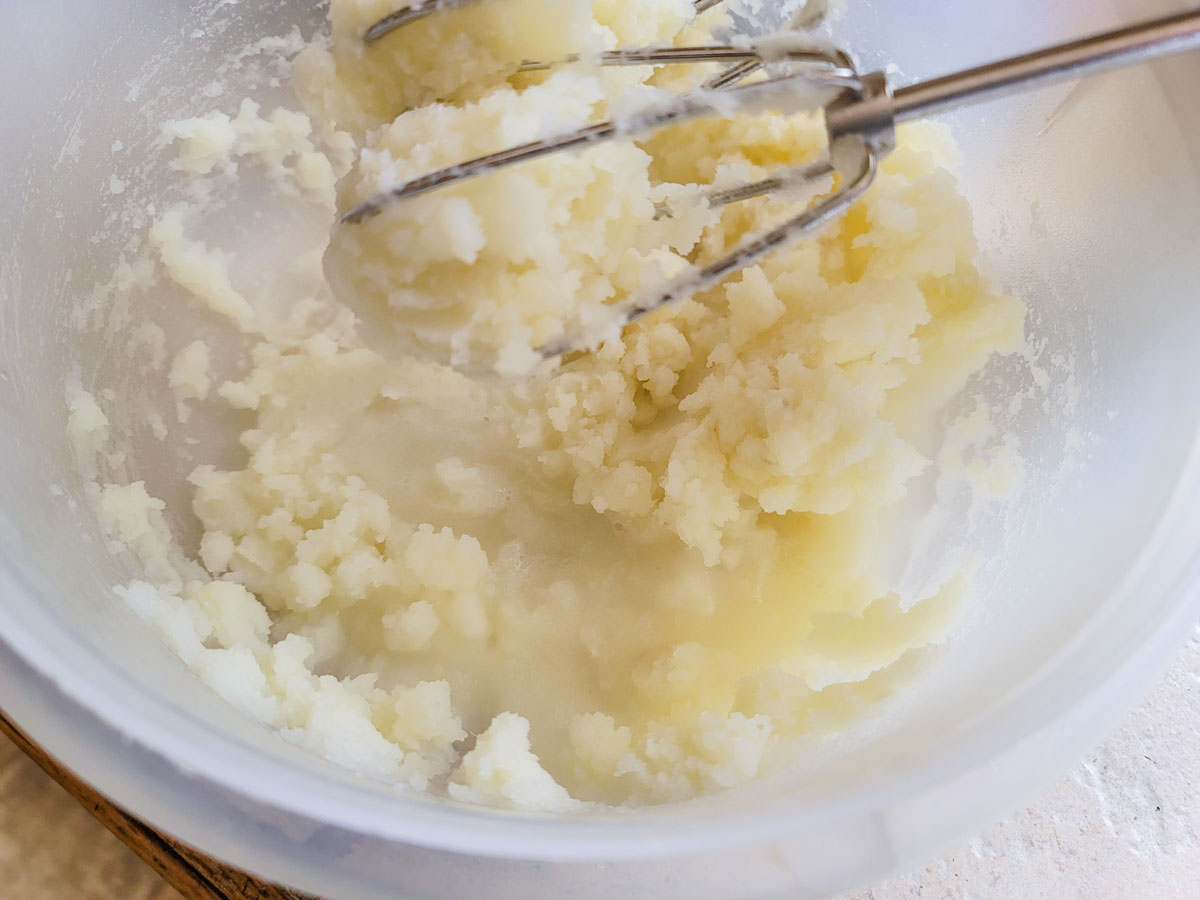 Partially mashed potatoes in a bowl.