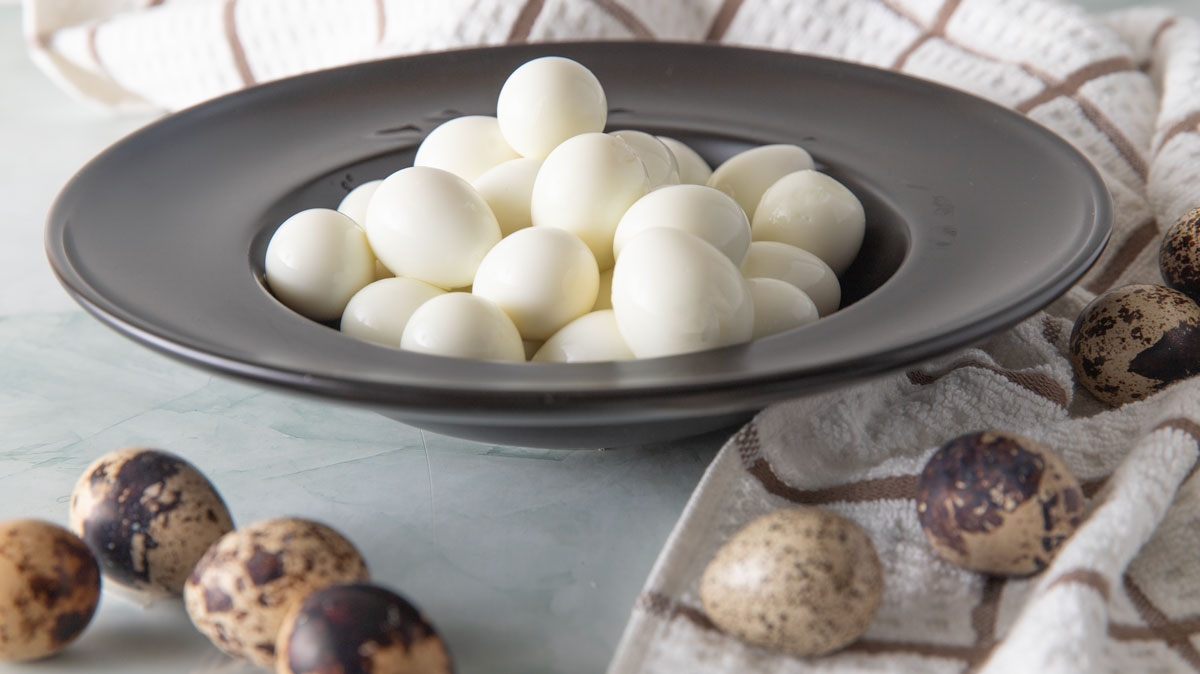 Side photo of hard boiled quail eggs in a bowl.