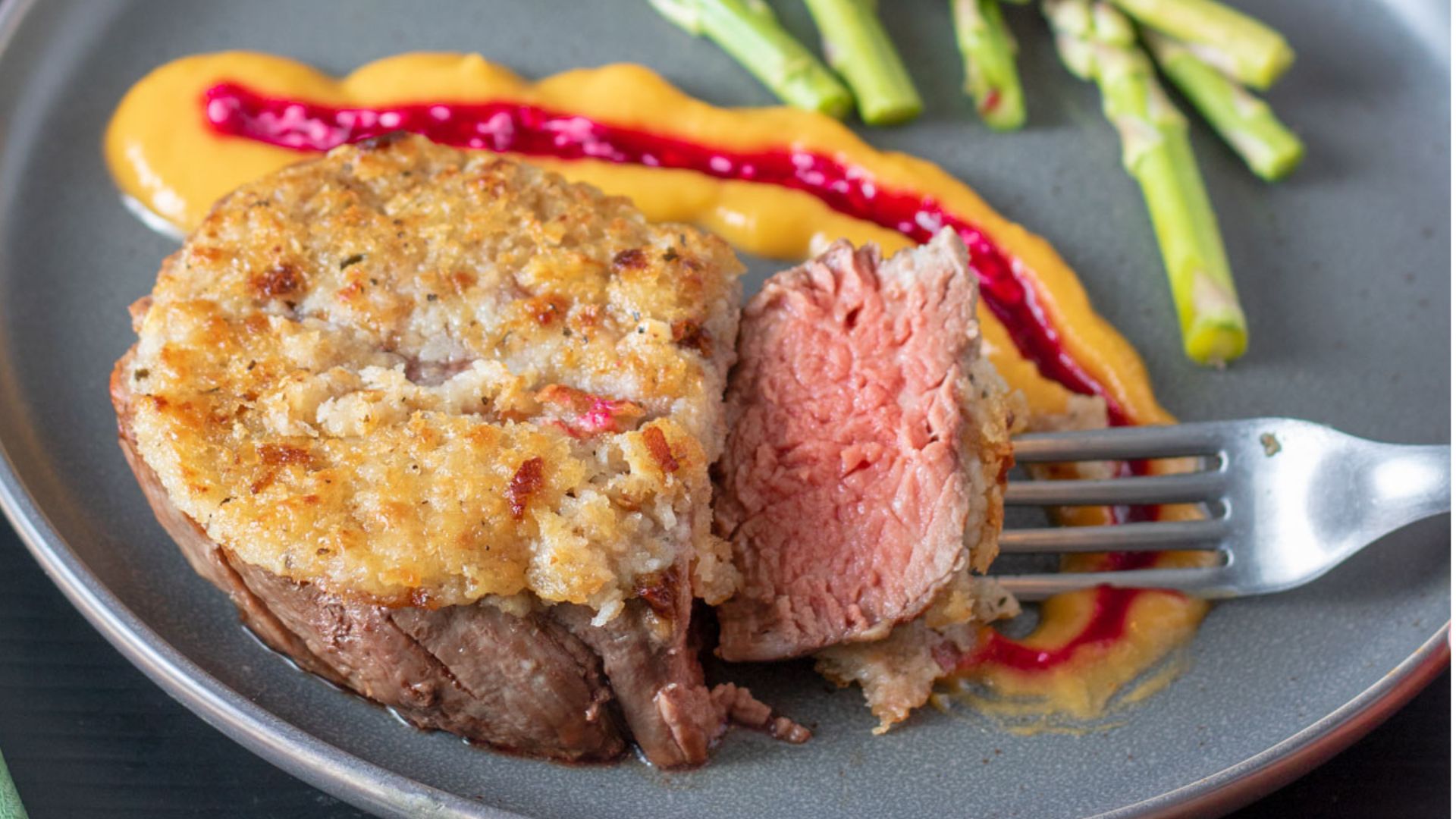 Fork holding a slice of beef tenderloin.
