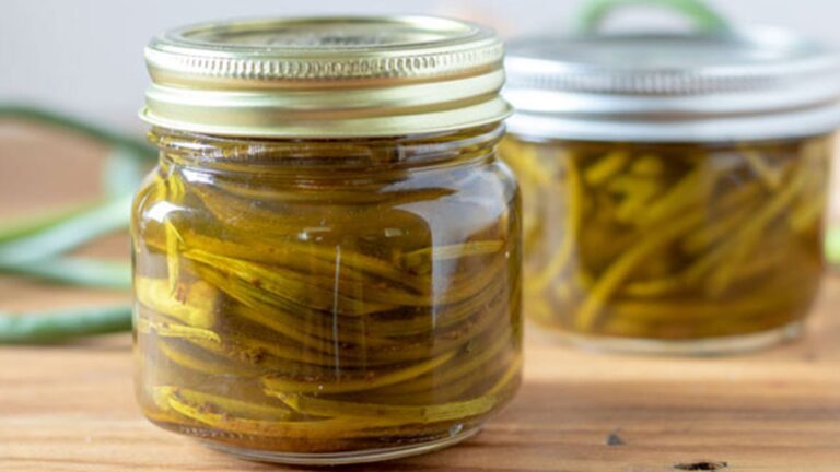 Pickled garlic scapes in jars.