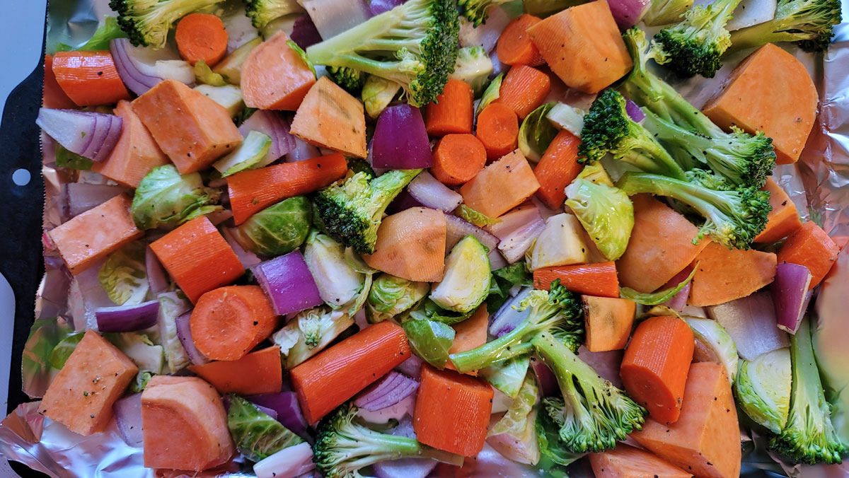 Vegetables spread on a foil-lined baking sheet.