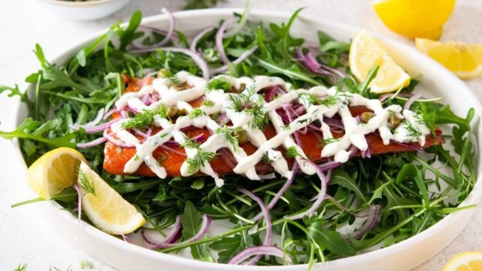 Smoked trout on a bed of arugula on a platter.