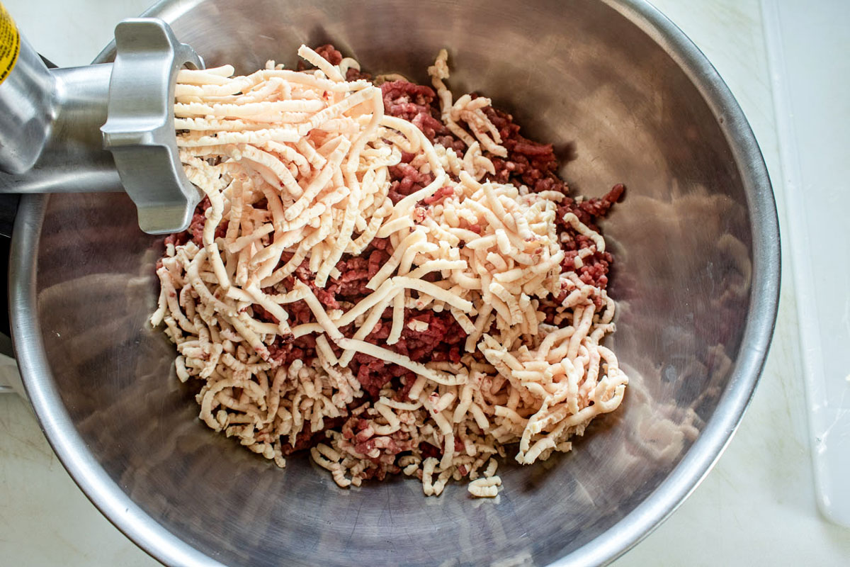 Grinding meat with a meat grinder.
